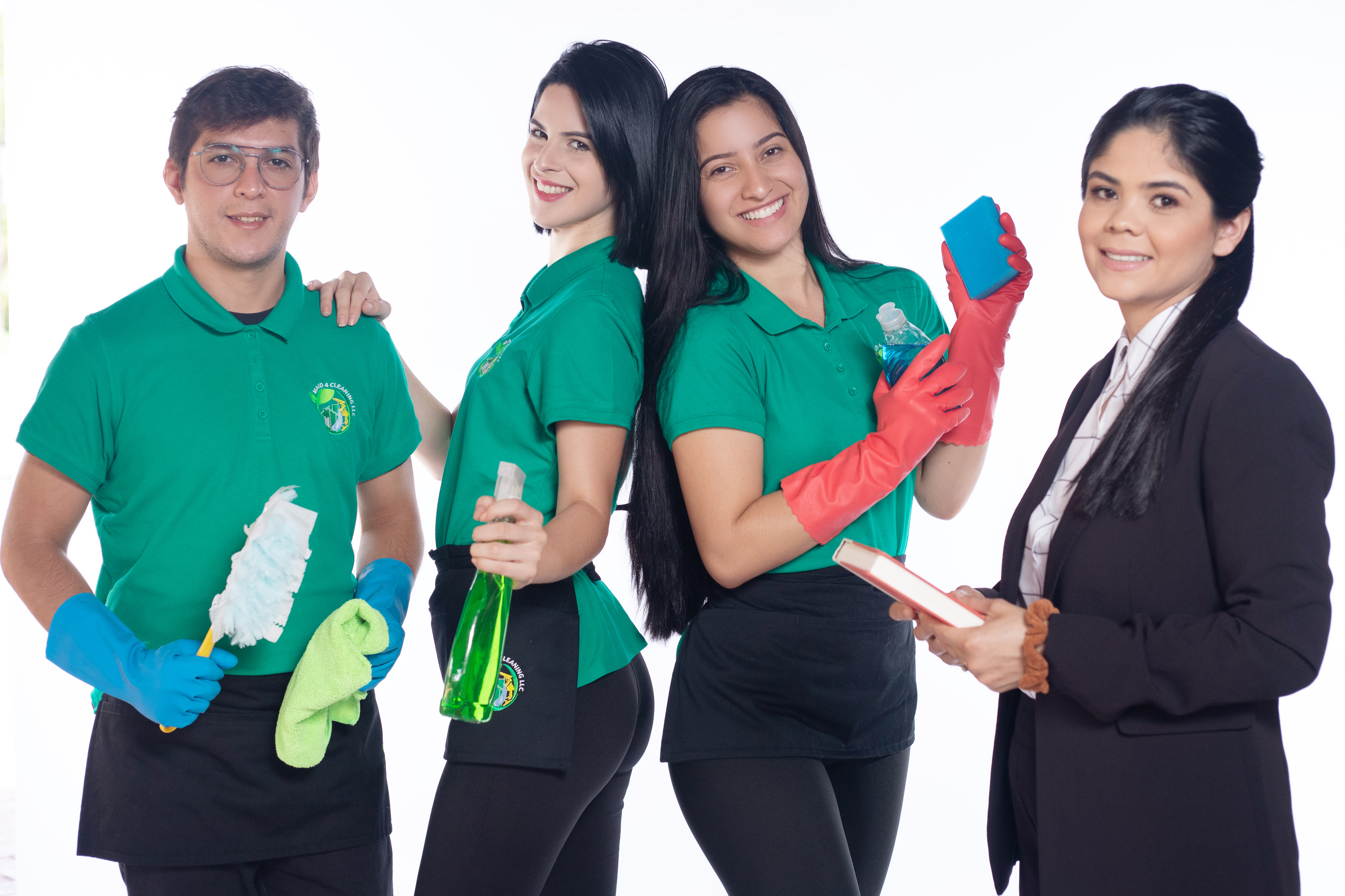 A professional cleaning team in green uniforms holding cleaning supplies, ready to assist with post-vacation home cleaning. A businesswoman stands beside them, representing quality and reliability in cleaning services.