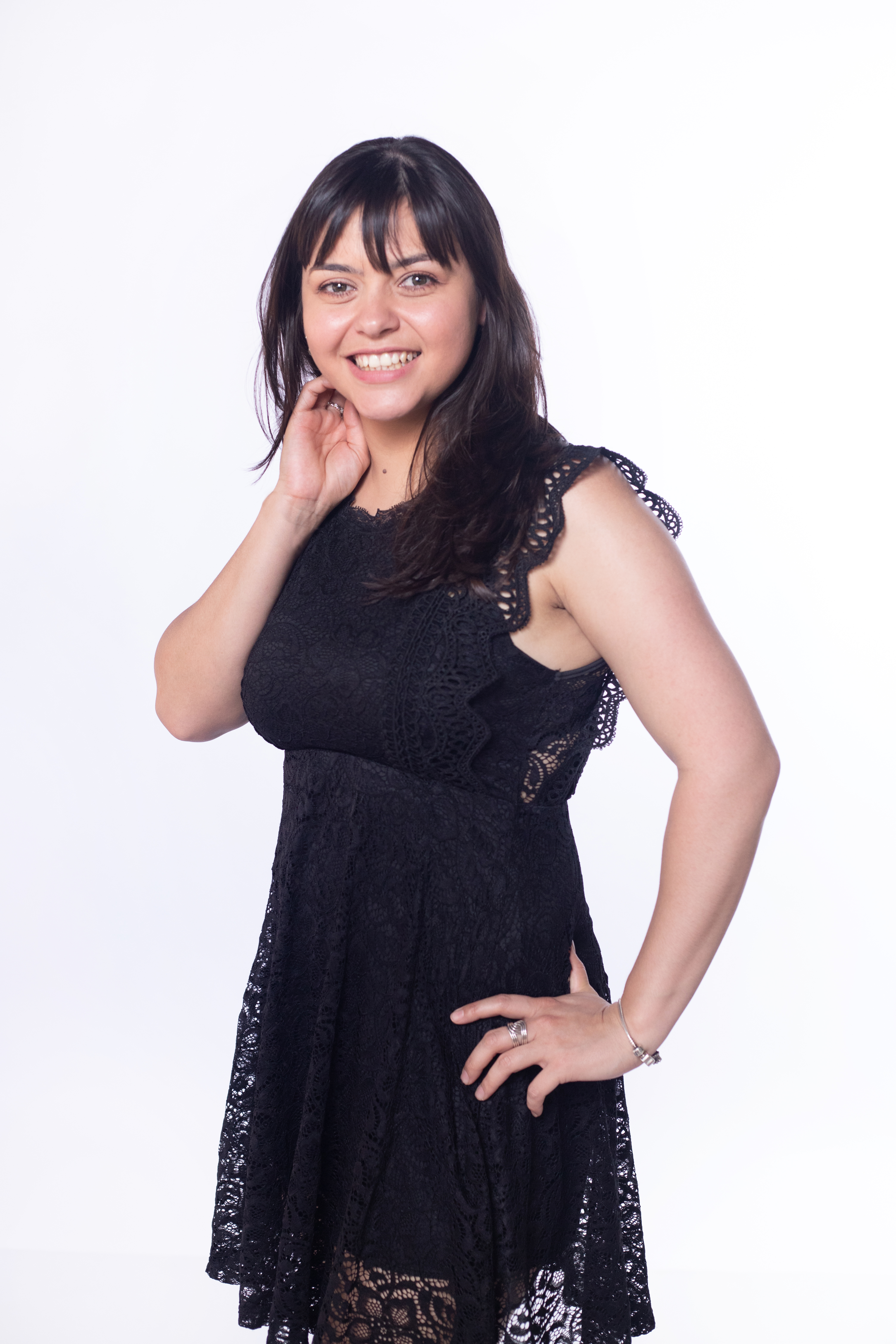 A woman in a black lace dress smiling confidently, representing a professional and knowledgeable cleaning expert. Her friendly demeanor aligns with the safe and effective cleaning advice shared in the blog post.